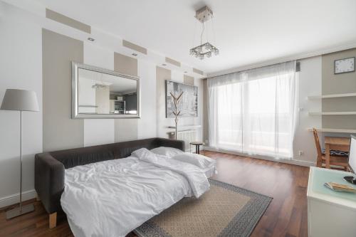 1 dormitorio con cama y espejo en la pared en Warta River Sleep Well Apartment en Poznan