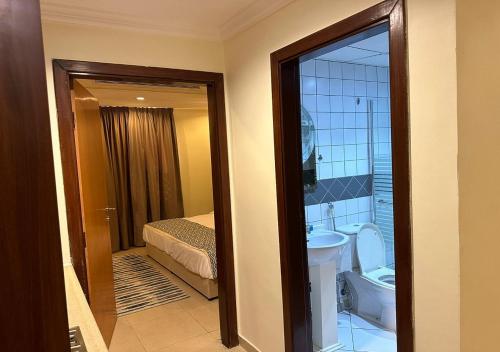 Habitación con baño con aseo y cama. en فندق الفرسان en Yeda