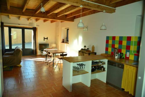 - une cuisine avec un comptoir et une table dans une pièce dans l'établissement La pensée sauvage, accueil, partage et ressourcement à la ferme, à Rimont