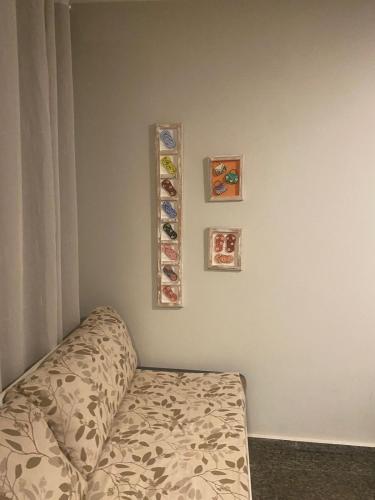 a room with a bed and some pictures on the wall at Segunda Casa- Seu cantinho na Praia do Morro em Guarapari - Quartos suítes 2 até 4 pessoas in Guarapari