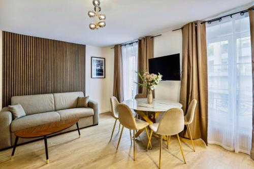 a living room with a table and chairs and a couch at Beautiful 2BDR near the Eiffel Tower in Paris