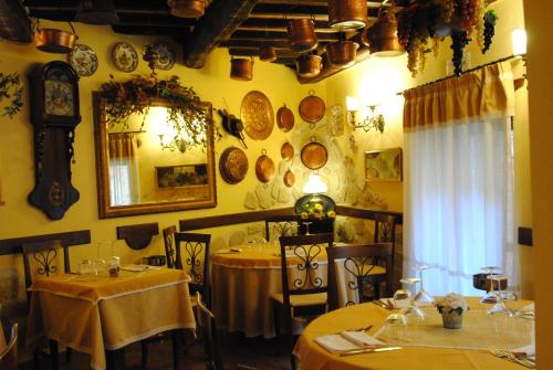 a restaurant with two tables and a mirror on the wall at Torre Sangiovanni Albergo e Ristorante da Rosary in Todi