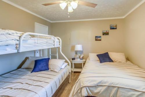 1 Schlafzimmer mit 2 Etagenbetten und einem Deckenventilator in der Unterkunft North Carolina Abode - Deck and Grill, Walk to Beach in Oak Island