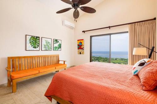 a bedroom with a bed and a window with the ocean at Casa de la Paz in Playa Hermosa