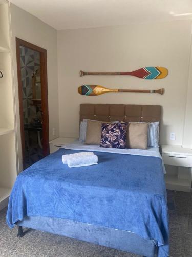 a bedroom with a bed with a blue blanket at Segunda Casa- Seu cantinho na Praia do Morro em Guarapari - Quartos suítes 2 até 4 pessoas in Guarapari