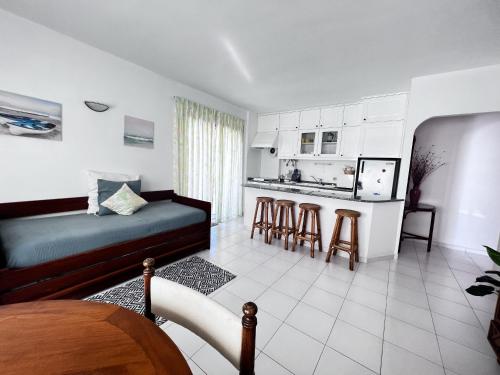ein Wohnzimmer mit einem Bett und eine Küche in der Unterkunft Caparica Ocean View in Costa da Caparica