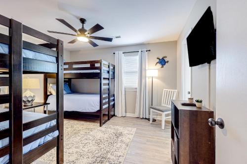 a bedroom with bunk beds and a desk with a ceiling fan at Palm 31 in Myrtle Beach