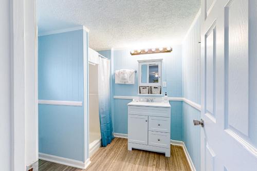 La salle de bains bleue est pourvue d'un lavabo et d'un miroir. dans l'établissement Palm 31, à Myrtle Beach