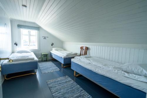 2 bedden in een kamer met een wit plafond bij Lofoten Island Lodge in Henningsvær