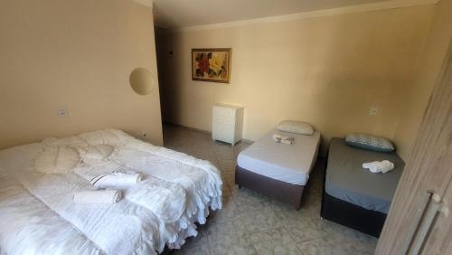 a room with two beds and two tables in it at Casa Feliz in Cascavel