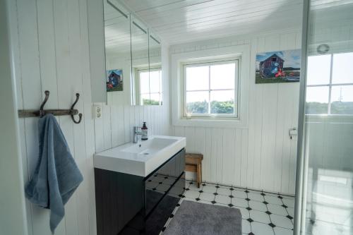 een witte badkamer met een wastafel en een douche bij Lofoten Island Lodge in Henningsvær