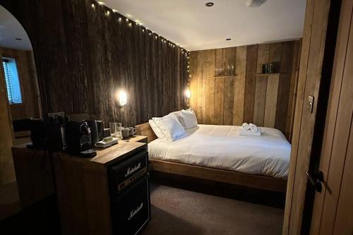 ein Schlafzimmer mit einem Bett und einem Schreibtisch mit einem Fernseher in der Unterkunft Quirky Retreats - The Hidden Retreat in Windermere