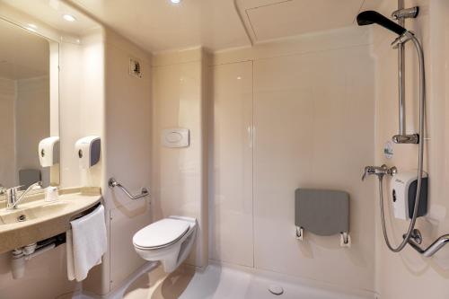 a bathroom with a shower and a toilet and a sink at Premiere Classe Bethune Fouquières Lès Béthunes in Fouquières-lès-Béthune