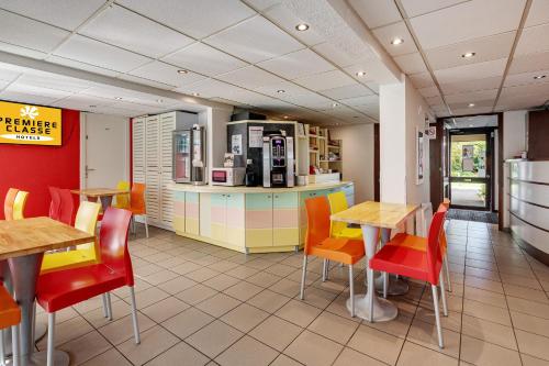 a fast food restaurant with tables and chairs at Premiere Classe Bethune Fouquières Lès Béthunes in Fouquières-lès-Béthune