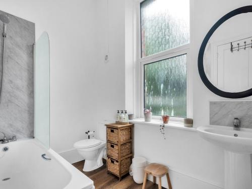 a white bathroom with a tub and a sink and a toilet at Pass the Keys Spacious Sea Side apartment in Folkestone