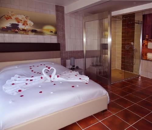 una camera da letto con un letto con cuori rossi sopra di La Pépite d'Amour, spa, sauna, piscine à volonté ! a Sainte-Anastasie-sur-Issole