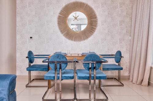 mesa de comedor con sillas azules y espejo en Bellavista - Relaxing - 1 BR - 29 Boulevard - Partial Burj Khalifa & Fountain View, en Dubái