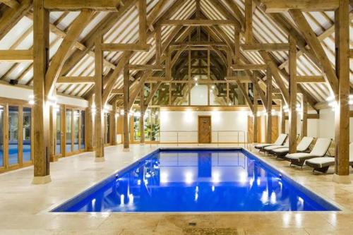 a large pool in a building with wooden ceilings at Country Gem in Tydd Saint Giles
