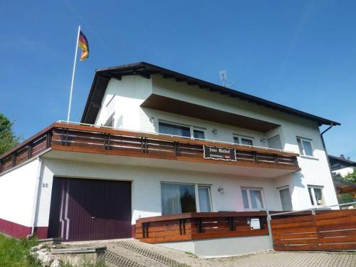 瓦爾德米歇爾巴赫的住宿－Haus Waldeck，白色的房子,上面有旗帜