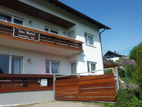 ein Haus mit einem Holzzaun davor in der Unterkunft Haus Waldeck in Wald-Michelbach