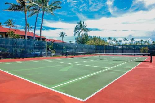 einen Tennisplatz mit Palmen im Hintergrund in der Unterkunft 1BR Condo at Oceanfront Resort Kapaa Shore in Kapaa