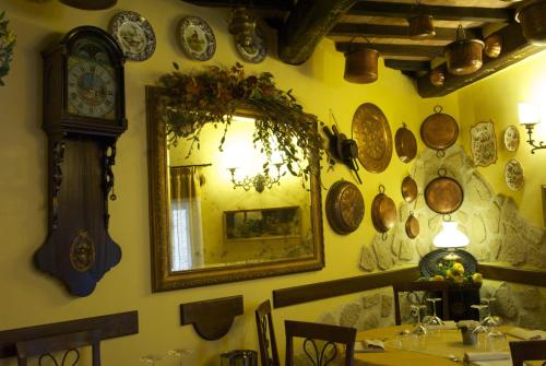 a dining room with a mirror and a clock on the wall at Torre Sangiovanni Albergo e Ristorante da Rosary in Todi