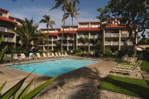 a resort swimming pool with lounge chairs and a resort at 1BR Condo at Oceanfront Resort Kapaa Shore in Kapaa