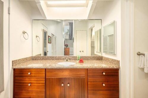 a bathroom with a sink and a large mirror at 1BR Condo at Oceanfront Resort Kapaa Shore in Kapaa