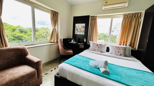 sypialnia z łóżkiem, krzesłem i oknami w obiekcie BluO Lake View NewTown - LUXE Stays Collection w mieście Kolkata