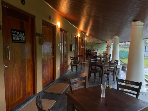 a dining room with tables and chairs in a restaurant at Eagles Eco Lodge - Kandy in Digana