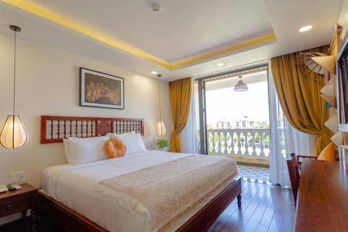 a bedroom with a large bed and a large window at Virgo Villa Quê Hội An in Hoi An