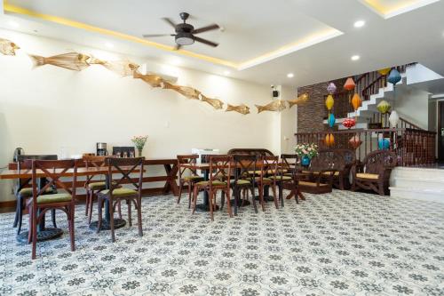 a dining room with wooden tables and chairs at Virgo Villa Quê Hội An in Hoi An