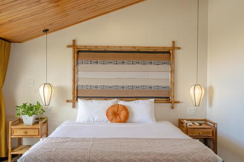 een slaapkamer met een groot bed met een houten hoofdeinde bij Virgo Villa Quê Hội An in Hội An