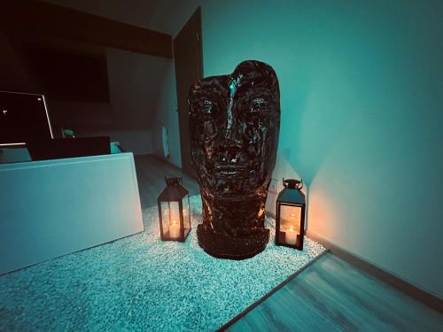 a statue with two candles in a room at Le Rêve d’une Nuit (suite CHARNELLE) in Réding