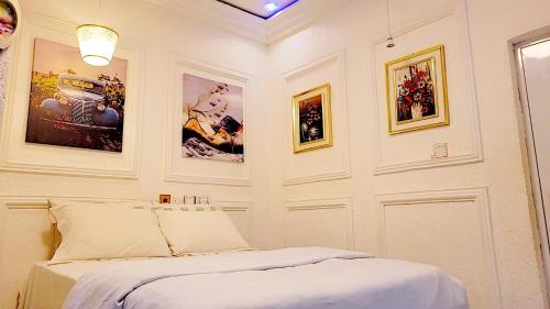 1 dormitorio con 1 cama y cuadros en la pared en Golden Aurora Lodge, en Kumasi