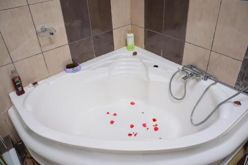 La salle de bains est pourvue de toilettes avec du sang sur la baignoire. dans l'établissement The Penthouse Suites Serviced Apartments Meru, à Meru