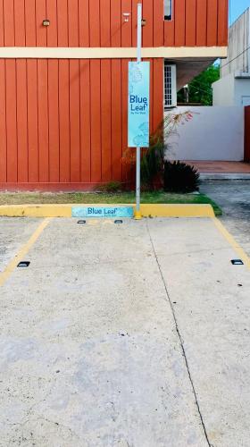 a parking lot with a sign in front of a building at Blue Leaf by the Sea in Luquillo
