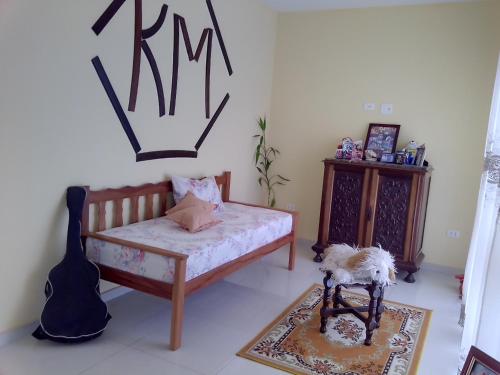 Un dormitorio con una cama y una guitarra. en Suíte para 4 pessoas - CE - 2 km Autódromo de Interlagos en São Paulo