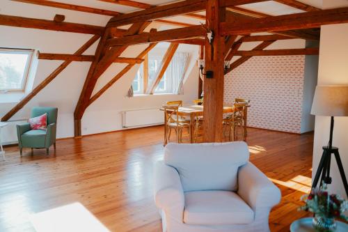 a living room with wooden ceilings and a table and chairs at Rittergut Hirschbach in Glashütte