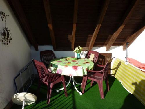 una mesa y sillas en una habitación con suelo verde en Ferienwohnung Koenig, en Wald-Michelbach