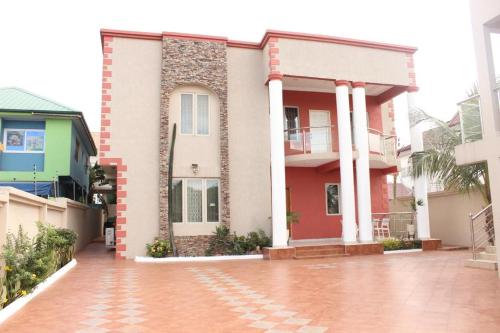 a house with a brick driveway in front of it at FREDA'S COURT in Accra
