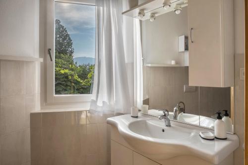 a bathroom with a sink and a window at Ferienhaus Weingut Plonerhof in Bolzano