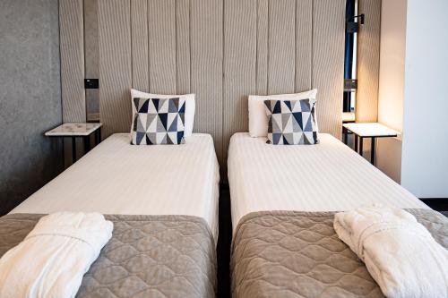 two beds sitting next to each other in a room at Union Plaza Hotel in Bucharest