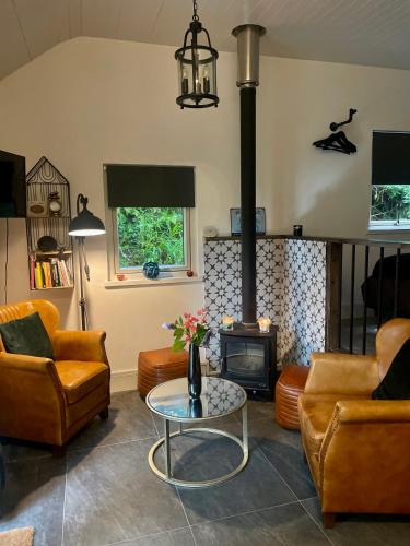 ein Wohnzimmer mit Möbeln und einem Holzofen in der Unterkunft Railway cottage Annascaul in Anascaul