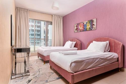 a hotel room with two beds and a tv at BellaVista Boulevard Central Spacious 2 Bedroom with maids room Burj Khalifa and Fountain View in Dubai