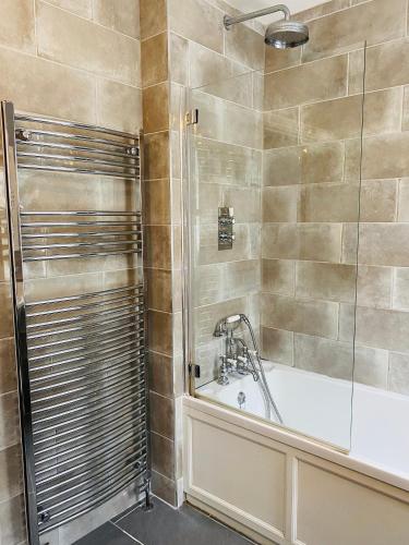 a bathroom with a bath tub and a shower at Ocean Terrace, Ilfracombe, 4 bedrooms, Sleeps 8, Stunning Sea Views, Parking, Garden, Pet Friendly in Ilfracombe