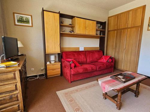 a living room with a red couch and a tv at Studio Villard-de-Lans, 1 pièce, 4 personnes - FR-1-515-106 in Villard-de-Lans