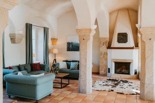 a living room with two couches and a fireplace at Rittergut Hirschbach in Glashütte
