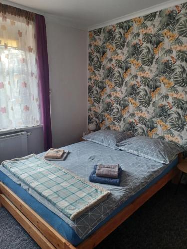 1 cama en un dormitorio con papel pintado con motivos florales en Apartament LORD, en Toruń