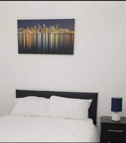 a bedroom with a white bed and a city skyline at Modern Stylish Two Bedroom Apartment in Beckenham